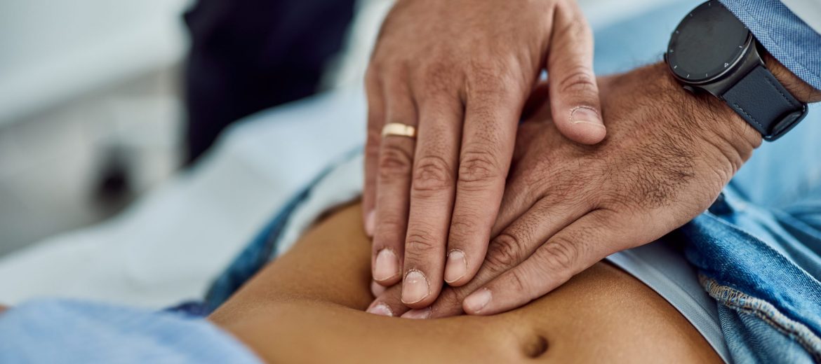 Medical Professional Examining Patient's Abdomen During Check-Up Appointment