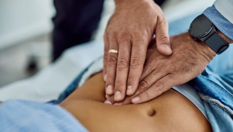 Medical Professional Examining Patient's Abdomen During Check-Up Appointment