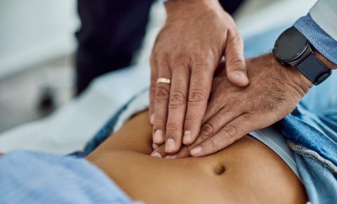 Medical Professional Examining Patient's Abdomen During Check-Up Appointment