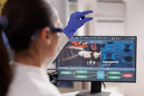 Microbiologist scientist woman holding slice with blood sample