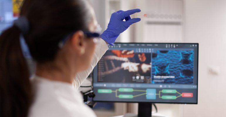 Microbiologist scientist woman holding slice with blood sample